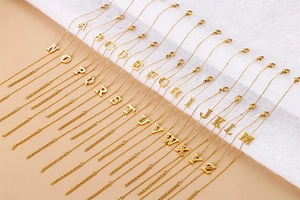 Detail view of gold-tone stainless steel alphabet bracelets with pave-set rhinestones