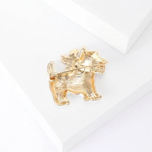 Cute enamel Corgi dog brooch in gold metal finish displayed on a white geometric stand