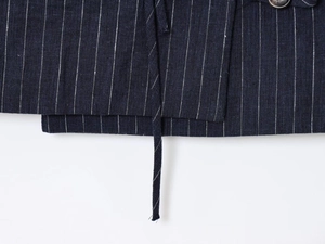 Detail of linen blend striped top hem and drawstring waist showing fabric texture