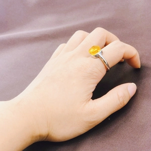 Minimalist silver stainless steel ring with square yellow zircon shown on a model hand