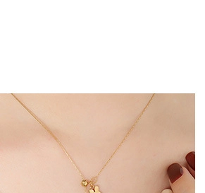 Nahaufnahme einer minimalistischen goldenen Hasen-Halskette am Hals eines Models