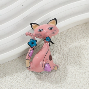 Close-up of pink enamel cat brooch with blue floral details and polished alloy finish