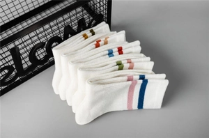 Close-up of white cotton crew socks featuring colorful double stripes and soft knit texture
