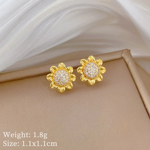 Macro shot of gold sunflower stud earrings with glittering cubic zirconia pavé details