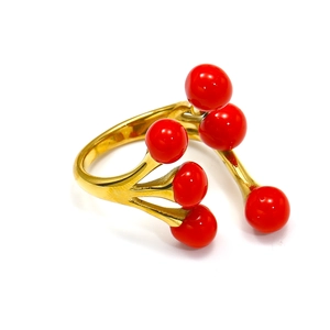 Detailed view of an artistic 18k gold-plated ring with vibrant red bead accents