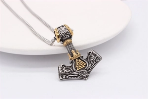 Detailed view of Mjolnir hammer pendant with golden Valknut symbol and ornate engravings