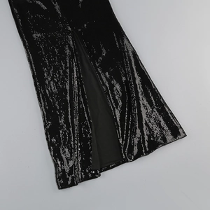 Close-up of black sequins fabric and elegant side slit detail on this evening dress