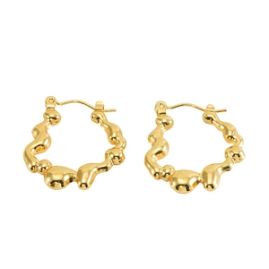 Detailed macro view of golden hollow earrings featuring an organic molten lava texture