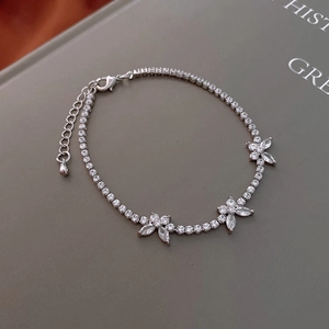 Close-up of silver zircon bracelet with floral clusters on a vintage book background