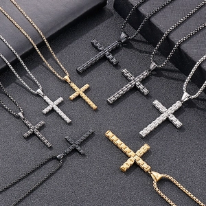 Pendentifs en croix texturés en or, argent et noir sur une surface texturée sombre