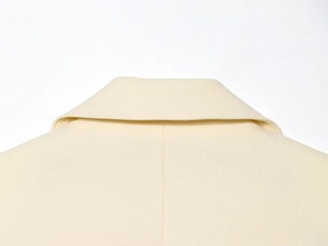 Vue macro de l'encolure du gilet beige montrant la texture du tissu tissé de qualité