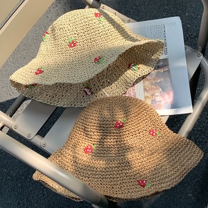 Women's straw sun hat with embroidered red strawberries on natural woven fabric