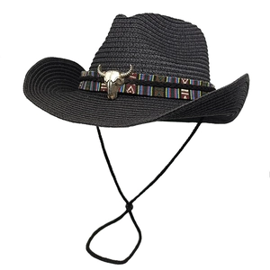Dettaglio cappello cowboy nero in paglia con fascia etnica e ciondolo a testa di toro