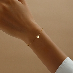 Close-up of S925 silver heart bracelet with star-set diamond on model wrist