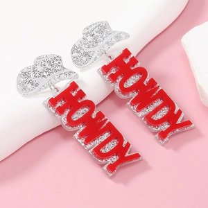 Detail of silver glitter cowboy hat earrings with red Howdy acrylic letter pendants