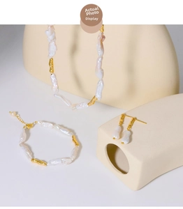 Detailed set of baroque pearl necklace, bracelet and earrings with golden metal accents