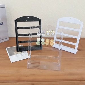 Three-color acrylic earring organizer stands in black, white, and clear with multi-hole design