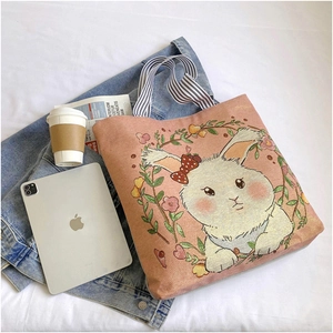 Detailed close-up of a pink canvas tote bag with a white rabbit and floral pattern