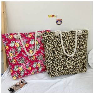 Detail of floral and leopard print canvas tote bags featuring thick rope knot handles