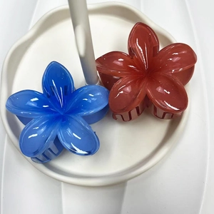 Macro detail of translucent gradient plumeria flower hair claws in blue and reddish brown