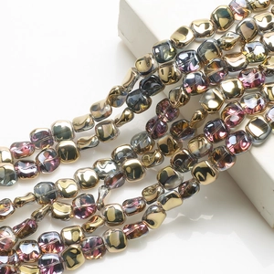 Macro detail of 12mm rhombus glass beads with holographic electroplated metallic finish