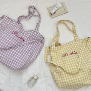 Close-up of purple and yellow plaid fabric tote bags with Sozakka embroidery