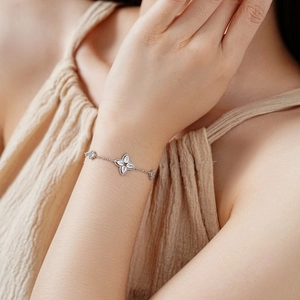 Detailed view of a silver-tone clover bracelet with four sparkling teardrop-shaped zircons