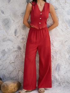 Detail of red sleeveless button-up vest and wide-leg trousers in textured cotton-linen fabric