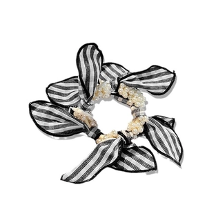 Classic black and white checkered bow scrunchie with elegant imitation pearls on a white background