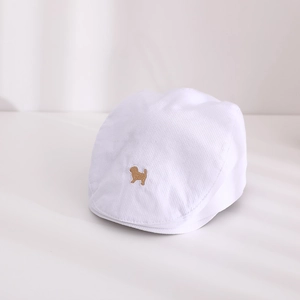 Détail d'un béret rayé pour bébé avec broderie de chien et texture velours côtelé