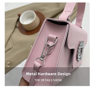 Détail d'un sac rose en cuir avec crochets argentés et boucle sertie de strass