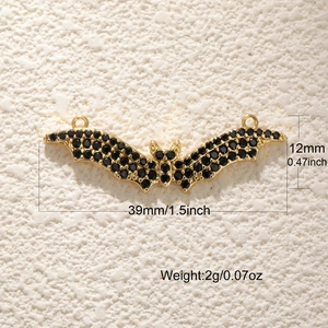 Vue détaillée du pendentif chauve-souris doré avec pierre noire et dimensions de 39 mm