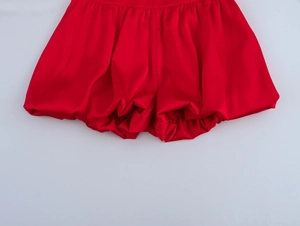 Vue détaillée d'un short bouffant en satin rouge avec plis élégants et fini soyeux