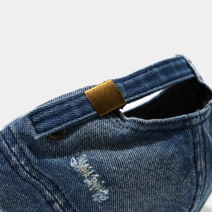 Détail de la casquette en jean délavé avec une boucle de réglage en métal bronze de style rétro