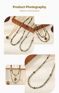 Detail of layered necklace featuring spotted natural stones and gold tiger eye pendant
