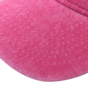 Detailed close-up of pink washed cotton baseball cap brim with five parallel stitching rows