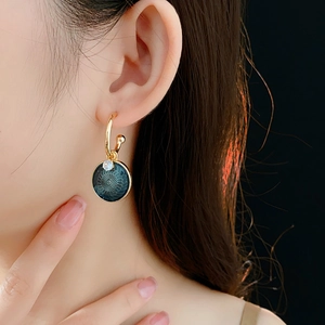 Close-up of vintage gold floral earrings with blue oil drop pendant and zircon stones
