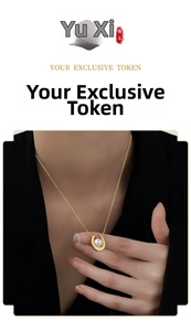 Detail of elegant U-shaped gold pendant with pearl worn on black outfit