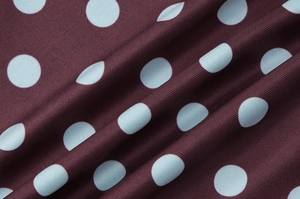 Vue macro détaillée du tissu bordeaux à pois bleu clair pour cet ensemble pour femmes