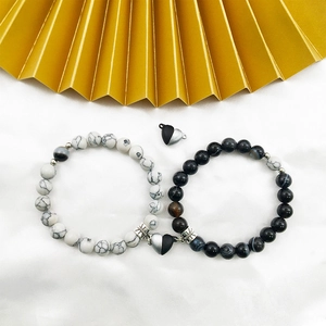 Detail of couple magnetic bead bracelets with heart clasp and stone texture beads