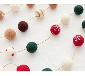 Detail of wool felt balls with snowflake embroidery on natural hemp rope for Xmas