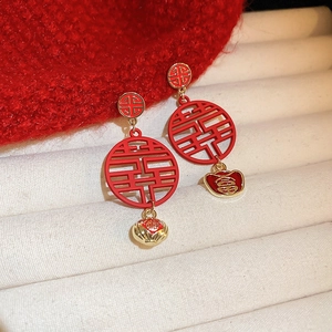 Detailed close-up of Chinese New Year earrings with Xi character and Fu bell pendants