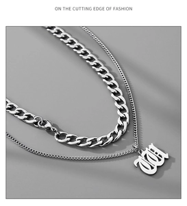 Detail of silver double-layer Cuban chain necklace with Gothic letter pendant