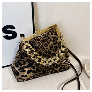 Close-up of leopard print shell bag featuring a bold gold chain handle and metal clasp