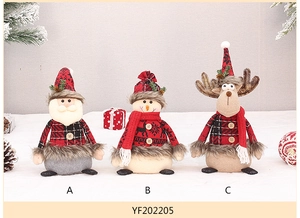 Detailed view of plush Christmas dolls featuring red plaid fabric and wooden button accents