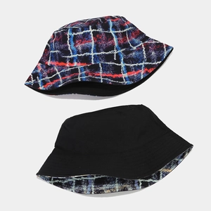 Detail view of reversible sun hat showing plaid pattern and solid black side in studio