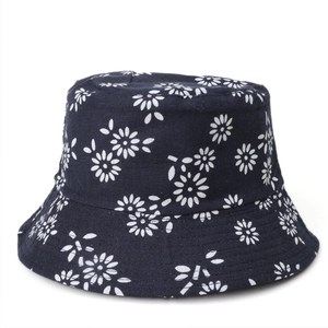 Close-up of navy blue cotton bucket hat with white daisy floral print for sun protection