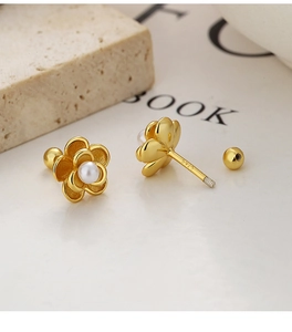 Detail view of gold flower pearl earrings with S925 silver stamp and screw back