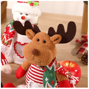 Close-up of a Christmas reindeer plush toy with a striped scarf in a festive holiday setting