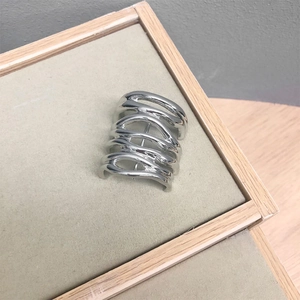 Close-up of a silver multi-layered wavy hair clip with a polished metallic finish